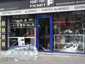 Une photo prise le 14 Juin 2016 montre la fenêtre brisée d'un magasin lors d'une manifestation contre la réforme du travail proposées à Paris. Plusieurs centaines de manifestants masqués ont lancé des objets à la police le 14 Juin lors d'une manifestation à Paris contre une réforme contestée du droit du travail français, selon les autorités. / AFP PHOTO / DOMINIQUE FAGET